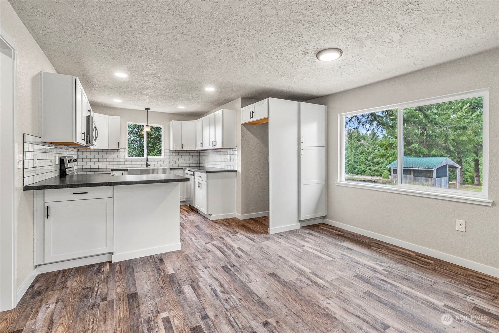 1541 Sightly Road Toutle, WA 98649 - Photo 7 of 30 a kitchen with a refrigerator a stove top oven and white cabinets