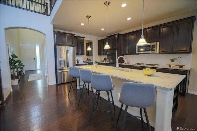 a kitchen with kitchen island a dining table chairs and a refrigerator