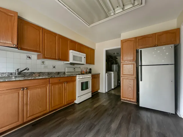 a kitchen with granite countertop white cabinets and white appliances