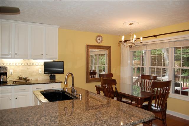 970 South Ridge Trail Clarksville, TN 37043 - Photo 5 of 20 The Lovely Kitchen Features A Large Granite Serving Bar, Tile Backsplash, and a Spacious Breakfast Area, as well as a Perfect View of the Deck and Outdoor Entertaining Area.