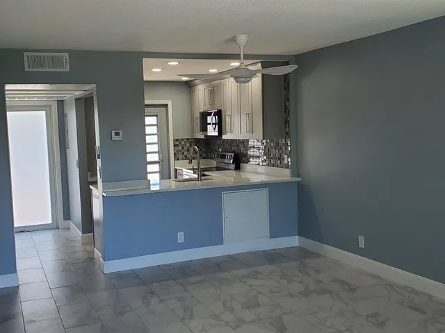 a bathroom with a granite countertop sink a mirror and shower