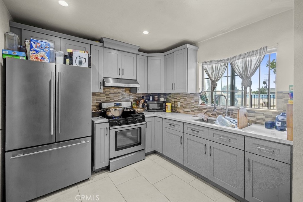 116 North Holly Avenue Compton, CA 90221 - Photo 12 of 23 a kitchen with stainless steel appliances granite countertop a refrigerator sink and cabinets