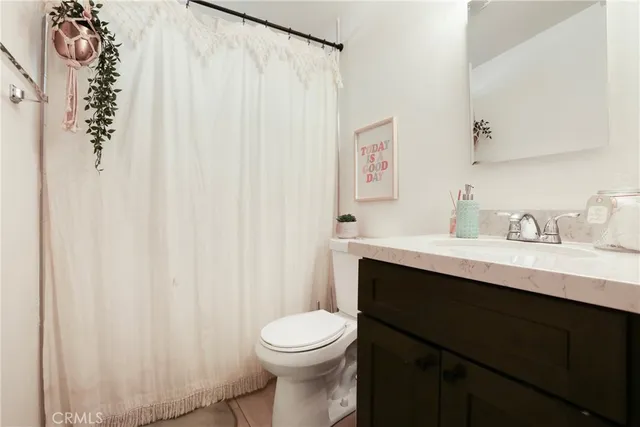 a bathroom with a sink a toilet and shower curtain