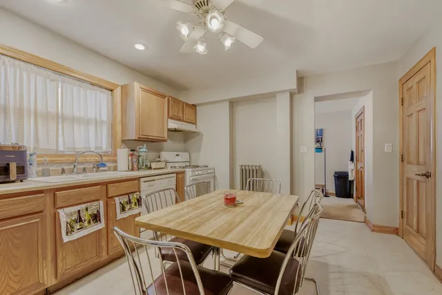 a kitchen with a table chairs refrigerator and cabinets