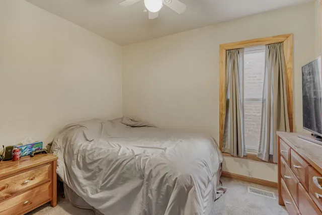 a bedroom with a bed and a flat tv screen on the dresser