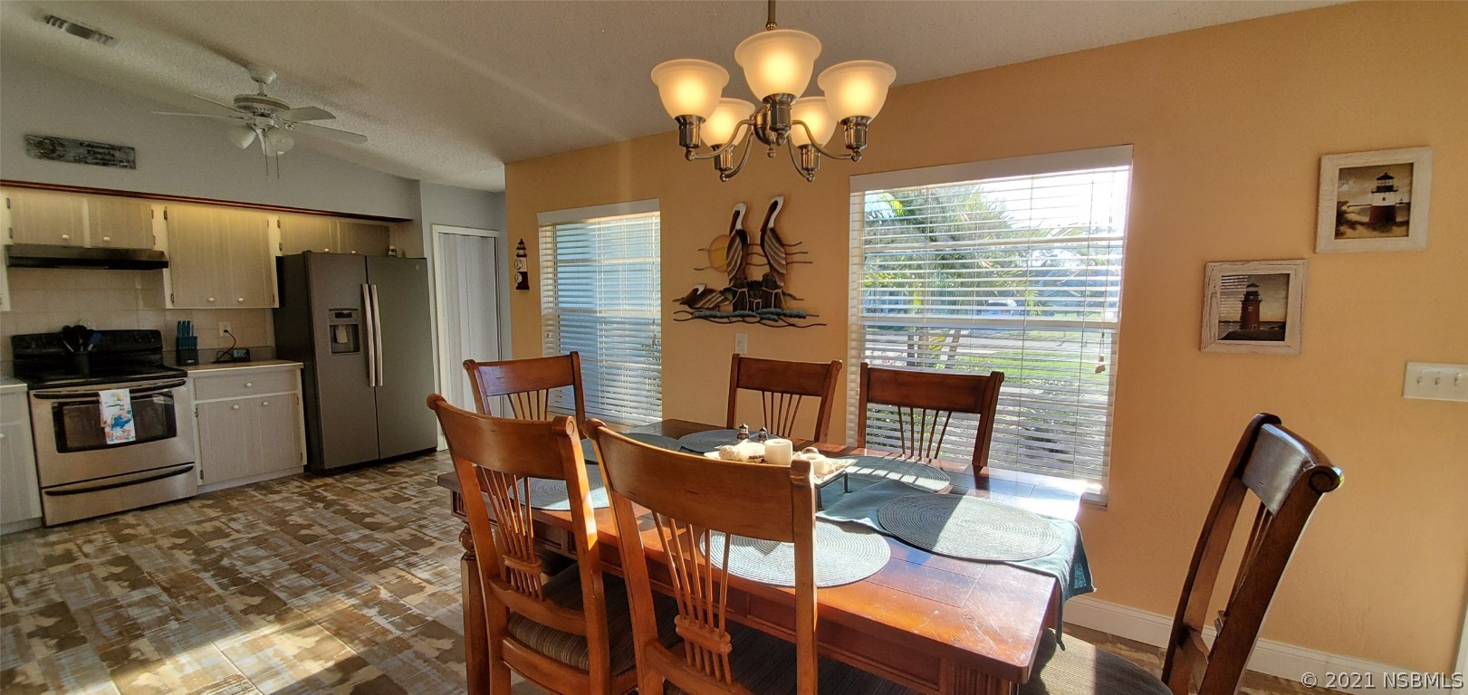 2219 Umbrella Tree Drive Edgewater, FL 32141 - Photo 27 of 45 a view of a dining room with furniture a chandelier and large windows