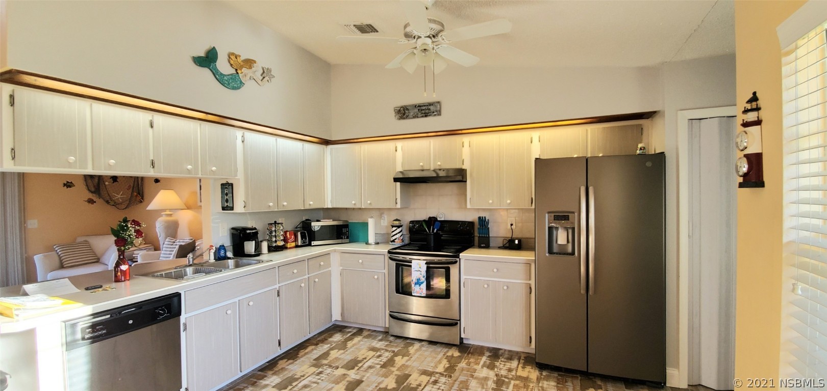 2219 Umbrella Tree Drive Edgewater, FL 32141 - Photo 29 of 45 a kitchen with stainless steel appliances a refrigerator sink and cabinets