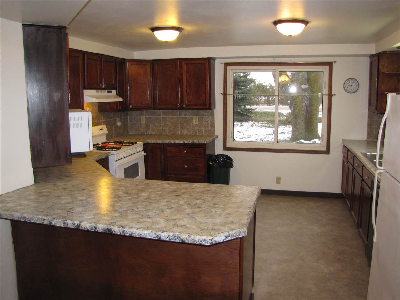 3634 Rotary Road Rockford, IL 61109 - Photo 4 of 18 a kitchen with granite countertop a stove a sink a refrigerator and wooden cabinets