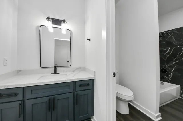 a bathroom with a toilet sink and mirror
