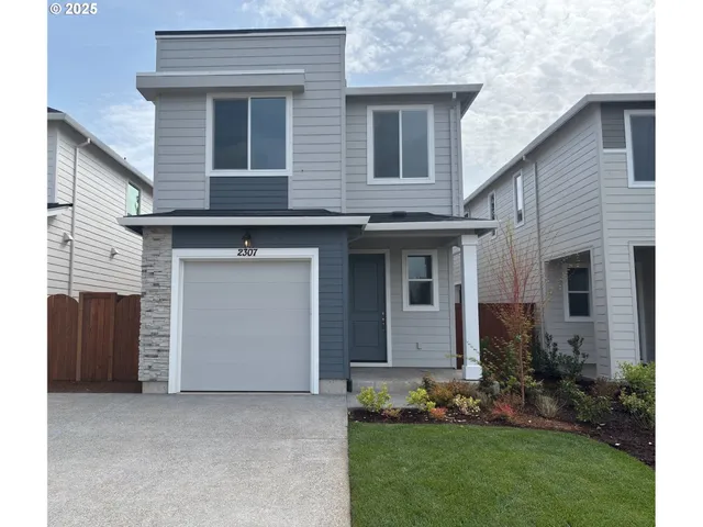 a front view of a house with a garden and garage