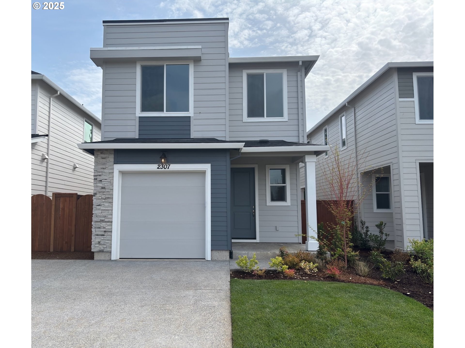 a front view of a house with a garden and garage