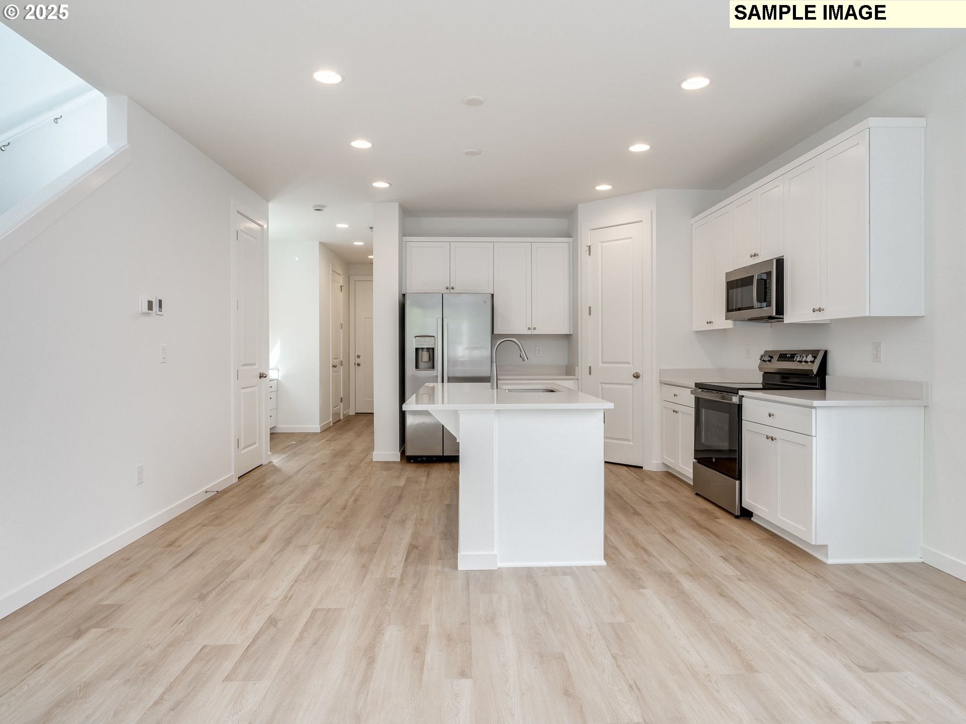 2307 Southwest 5th Circle Battle Ground, WA 98604 - Photo 12 of 21 a large white kitchen with kitchen island a sink a stove a refrigerator and white cabinets