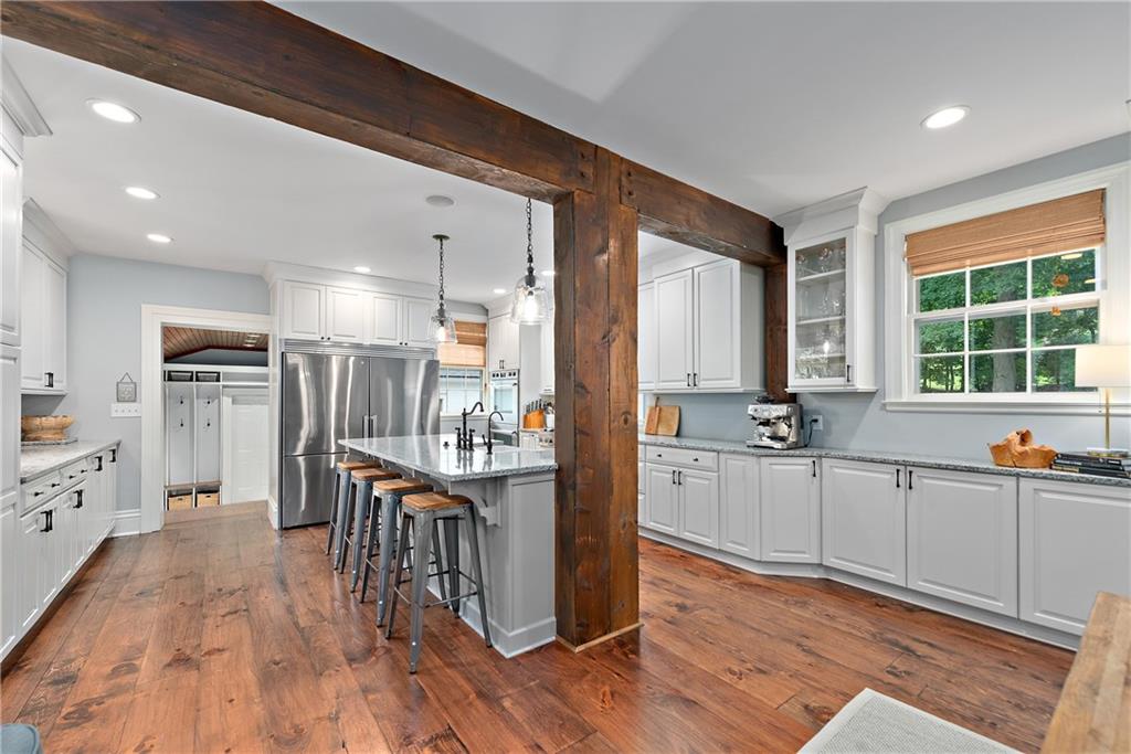 607 Davis Lane Sewickley, PA 15143 - Photo 14 of 43 a kitchen with stainless steel appliances kitchen island granite countertop a stove a refrigerator a sink a dining table and chairs with wooden floor