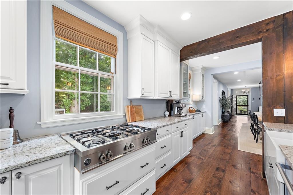 607 Davis Lane Sewickley, PA 15143 - Photo 17 of 43 a kitchen with a stove a sink dishwasher and white cabinets with wooden floor