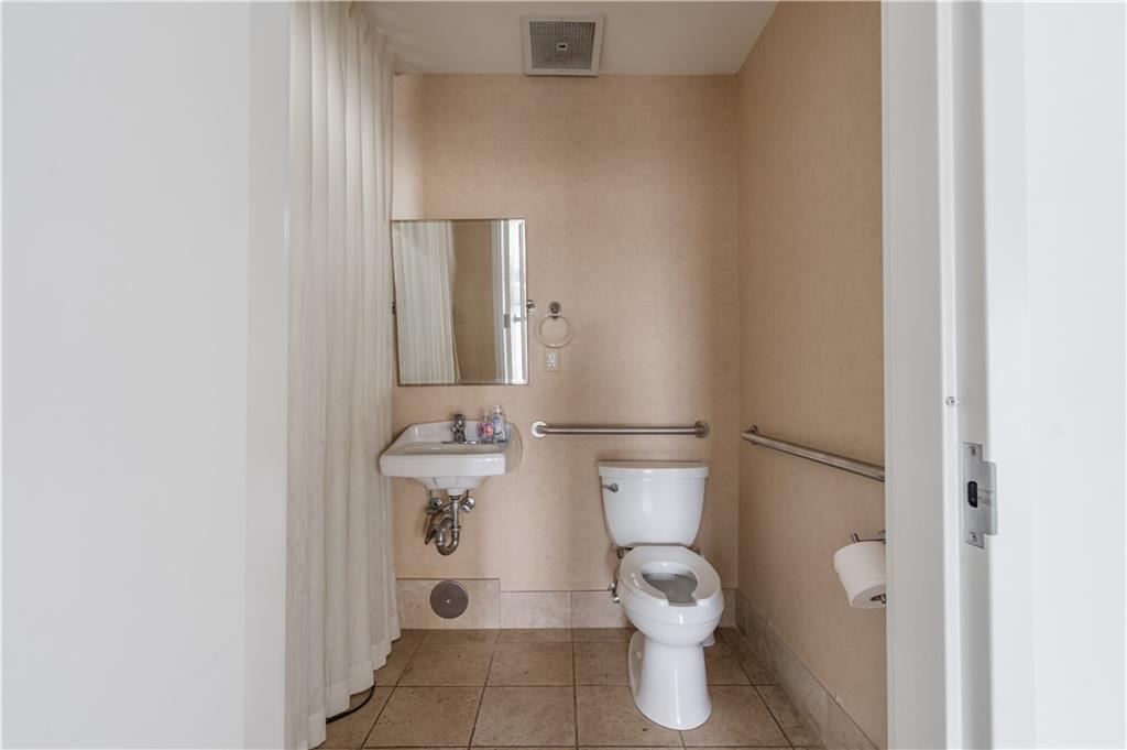 692 10th Street Northwest Atlanta, GA 30318 - Photo 14 of 38 a bathroom with a toilet and a shower