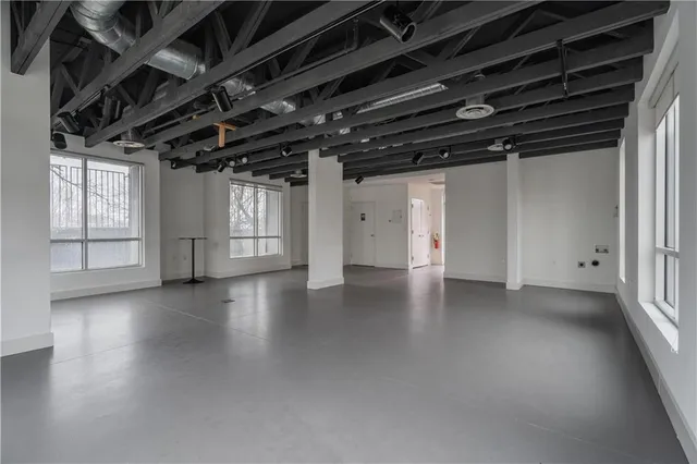 a view of empty room with wooden floor and windows