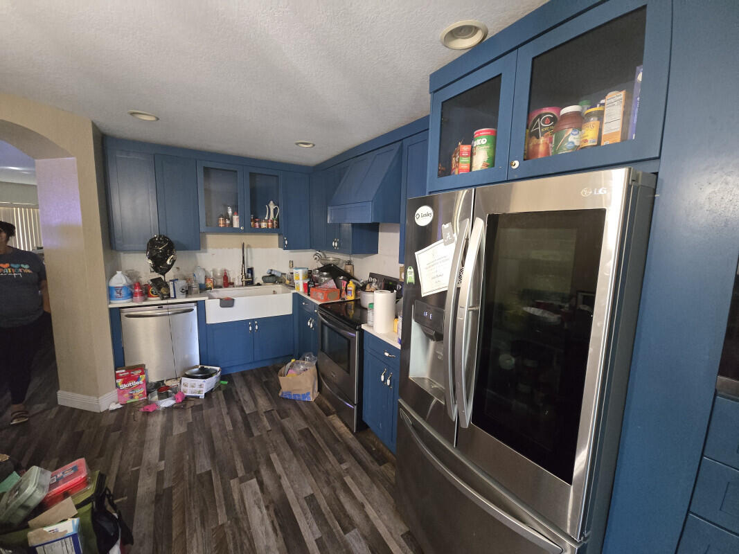 6511 Sandy Bank Terrace Riviera Beach, FL 33407 - Photo 9 of 12 a kitchen with a refrigerator and wooden floor