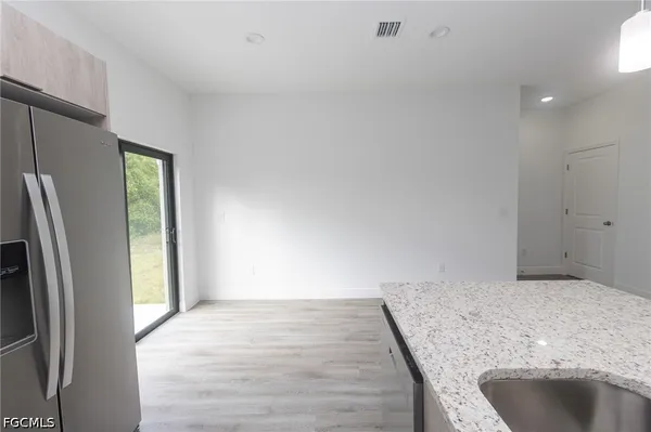 a view of a kitchen with a sink and refrigerator