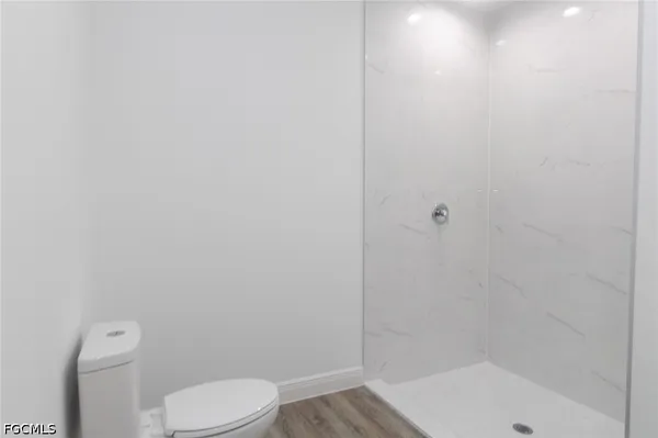 a white toilet sitting next to a bath tub and a shower