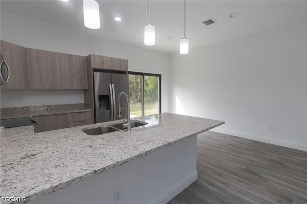 a kitchen with granite countertop a sink a counter space and cabinets