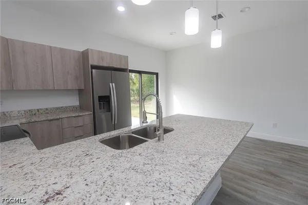 a kitchen with kitchen island a sink a stove and refrigerator