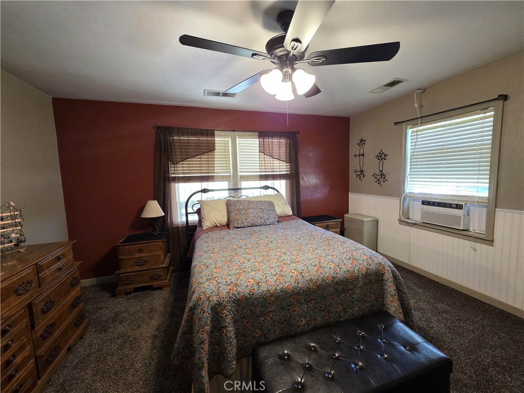 23773 River Road Corning, CA 96021 - Photo 23 of 64 a bedroom with a bed and a chandelier