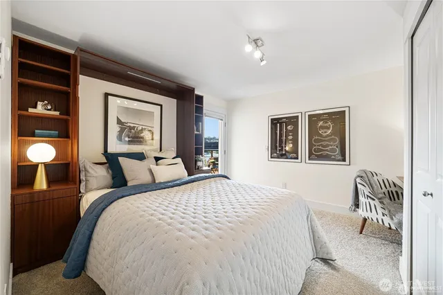 a bedroom with a bed and a large mirror with a dresser