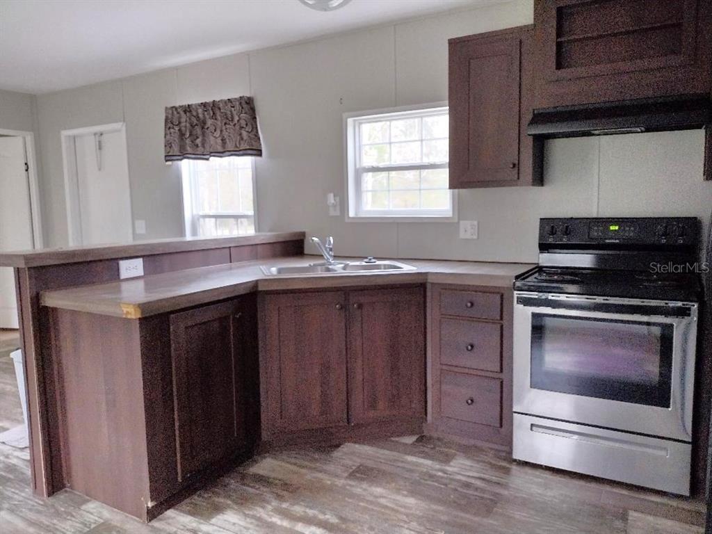 1568 Hazelnut Street Bunnell, FL 32110 - Photo 3 of 19 a kitchen with stainless steel appliances granite countertop a sink stove and cabinets