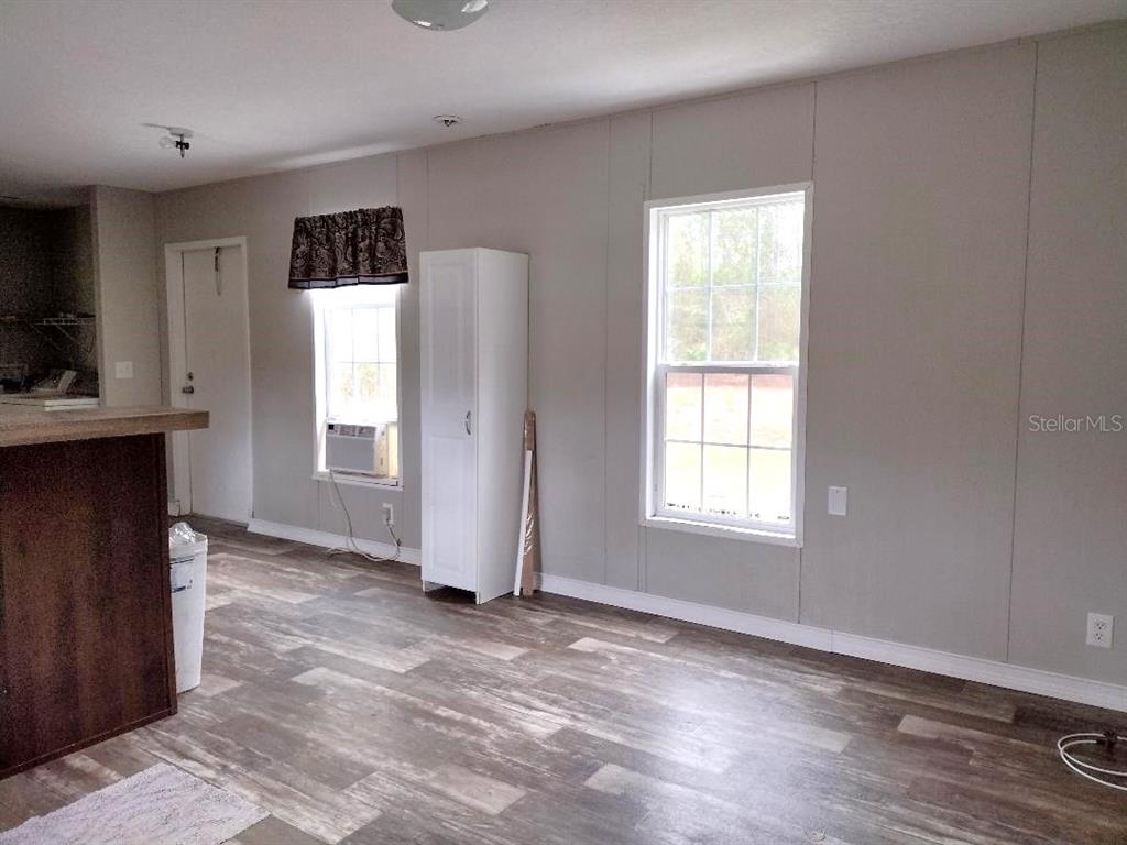 1568 Hazelnut Street Bunnell, FL 32110 - Photo 5 of 19 a view of an empty room with a window and wooden floor