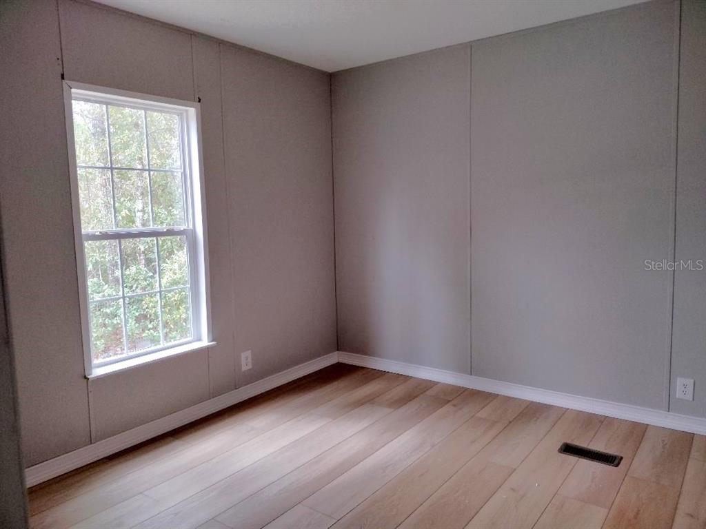 1568 Hazelnut Street Bunnell, FL 32110 - Photo 7 of 19 an empty room with wooden floor and windows