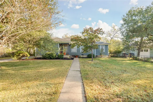a front view of a house with a yard and trees
