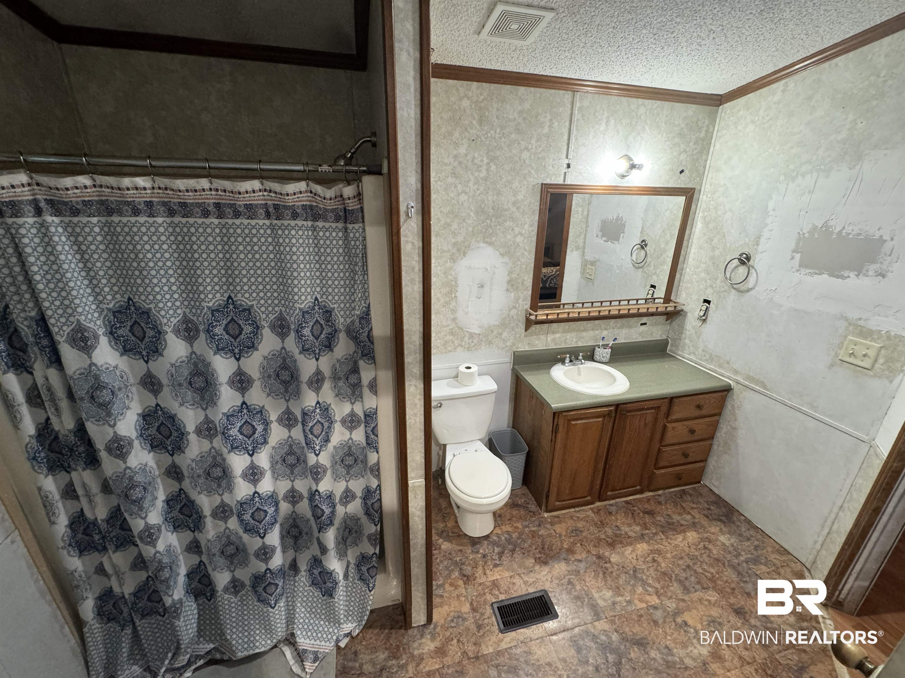 51235 Phillipsville Road Bay Minette, AL 36507 - Photo 30 of 63 Bathroom with vanity, curtained shower, a textured ceiling, crown molding, and stone finish floors
