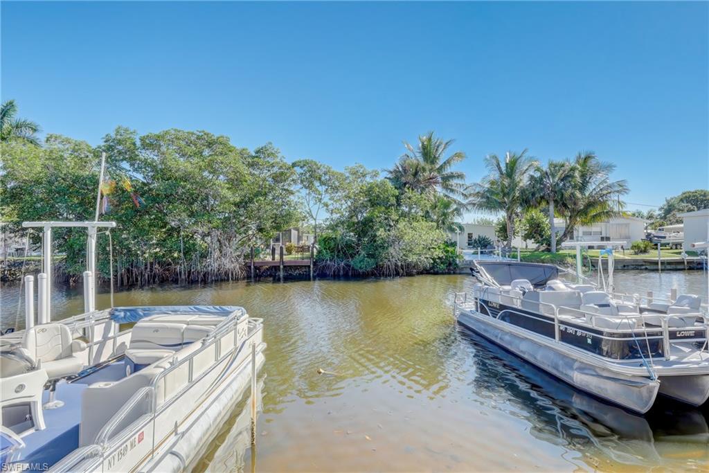 143 Rose Lane Naples, FL 34114 - Photo 6 of 13 a view of a patio with chairs next to a lake