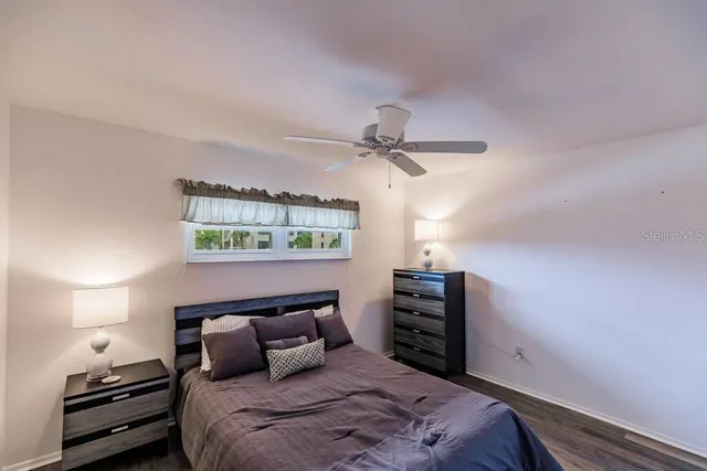 a bedroom with a bed and a lamp on dresser