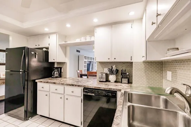 a kitchen with a refrigerator sink and cabinets