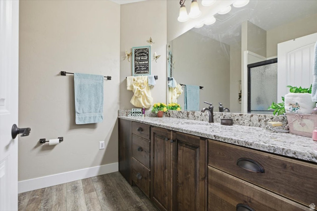 3123 East Riverdale Road Preston, ID 83263 - Photo 19 of 52 Vanity featuring wood-finish cabinetry, a light-toned countertop, and an integrated sink with a dark-finish faucet