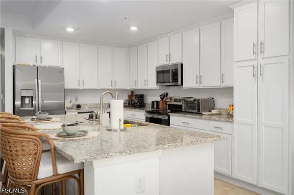 a kitchen with stainless steel appliances granite countertop a sink refrigerator and cabinets