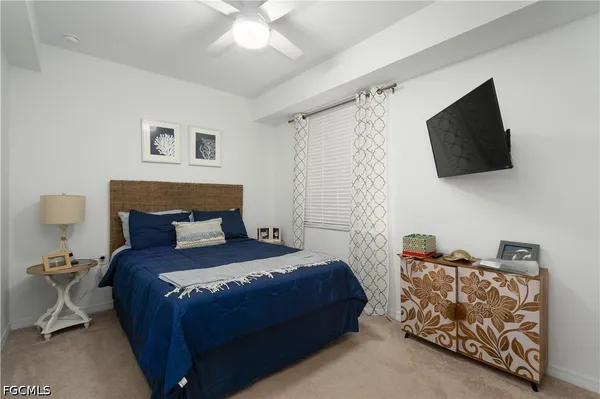 a bedroom with a bed and a flat tv screen on the dresser