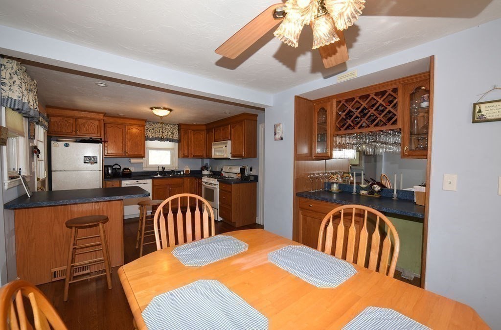 106 Rinaldo Road Weymouth, MA 02191 - Photo 8 of 39 a kitchen with a refrigerator a sink dishwasher a dining table and chairs with wooden floor