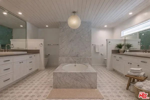 a large bathroom with a granite countertop sink a toilet a mirror and bathtub