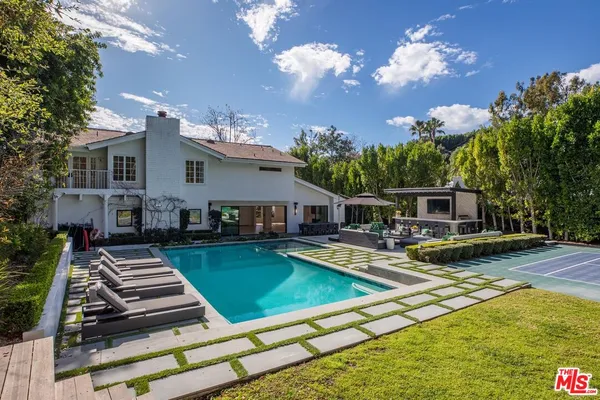 a view of a house with swimming pool and sitting area