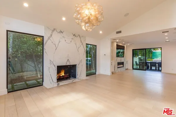 a view of a livingroom with a fireplace a chandelier and mountain view