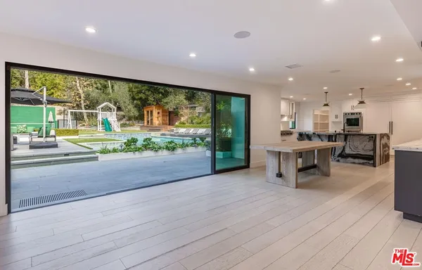 a kitchen with stainless steel appliances dining table chairs and a large window