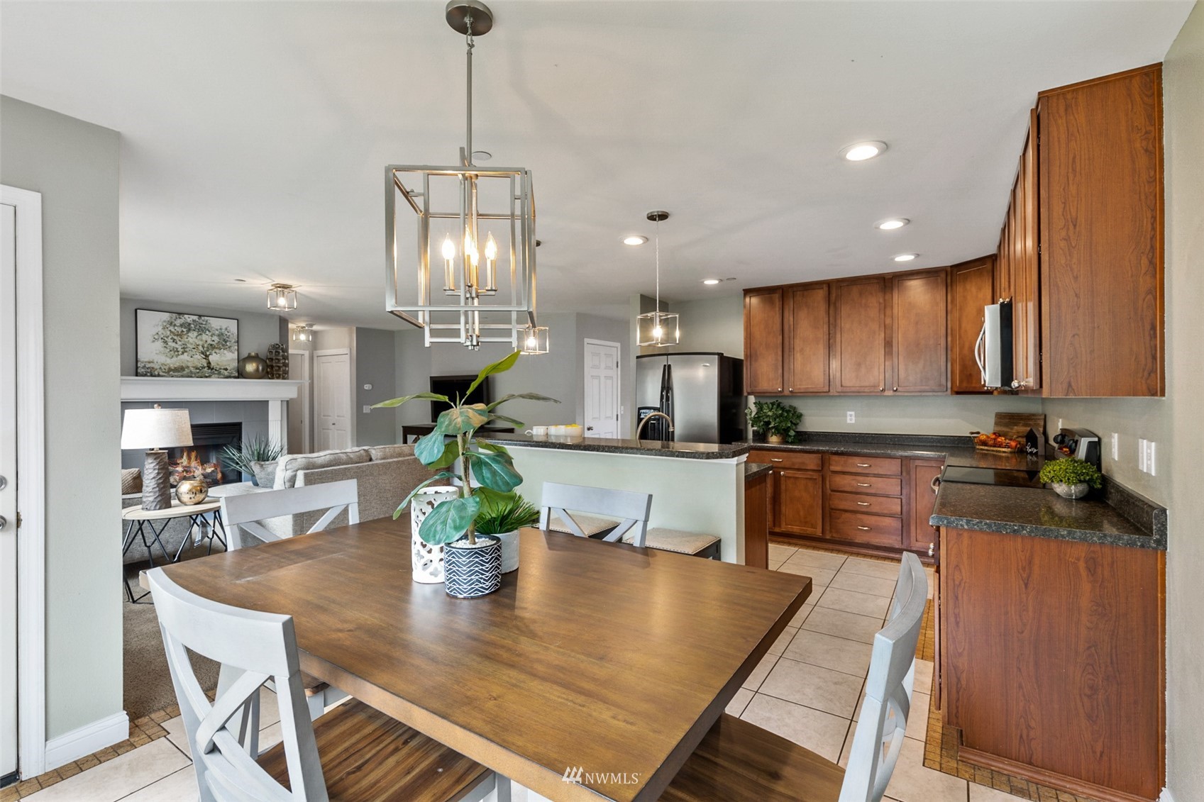 1360 Foreman Road DuPont, WA 98327 - Photo 7 of 33 a kitchen with stainless steel appliances granite countertop a refrigerator a sink a stove a dining table and chairs