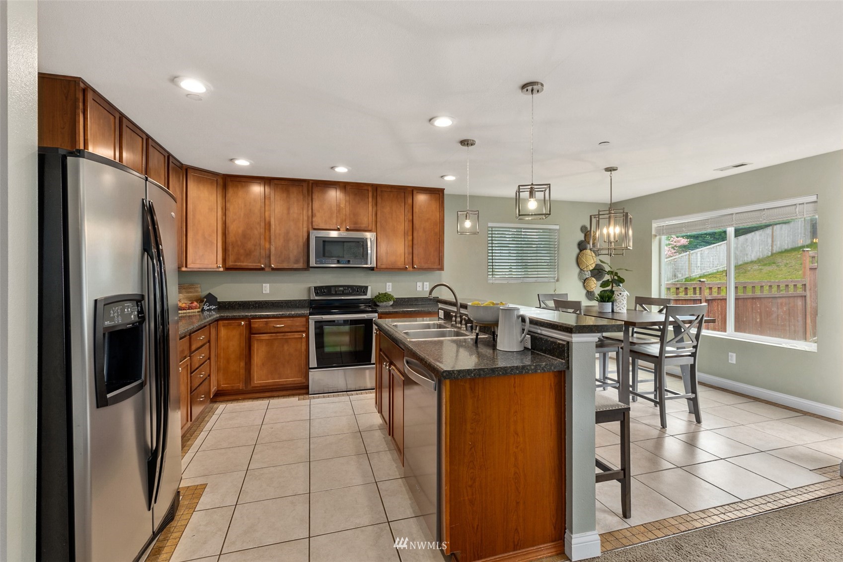 1360 Foreman Road DuPont, WA 98327 - Photo 8 of 33 a kitchen with stainless steel appliances granite countertop a stove top oven a sink dishwasher a refrigerator and white cabinets with wooden floor