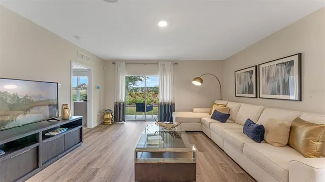 a living room with furniture and a wooden floor