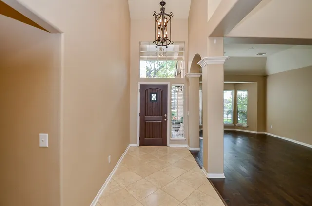 a view of a hallway with wooden floor and windows