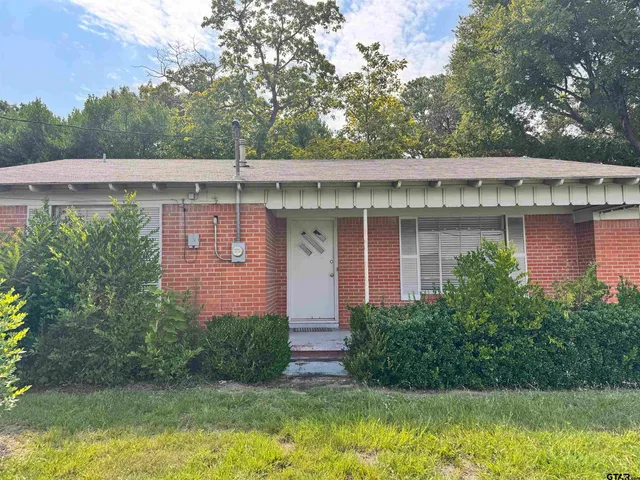 a view of a house with a large pool plants and large tree