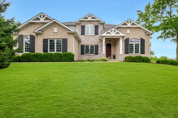a front view of a house with a garden