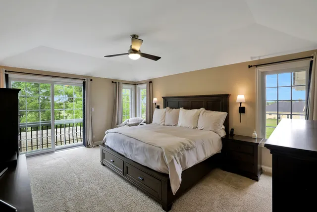 a spacious bedroom with a large bed and a chandelier